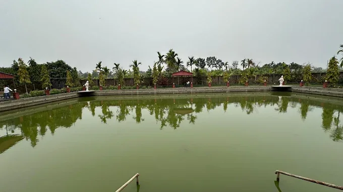 A wide view of the main pond with statues and gazebos reflected in the water