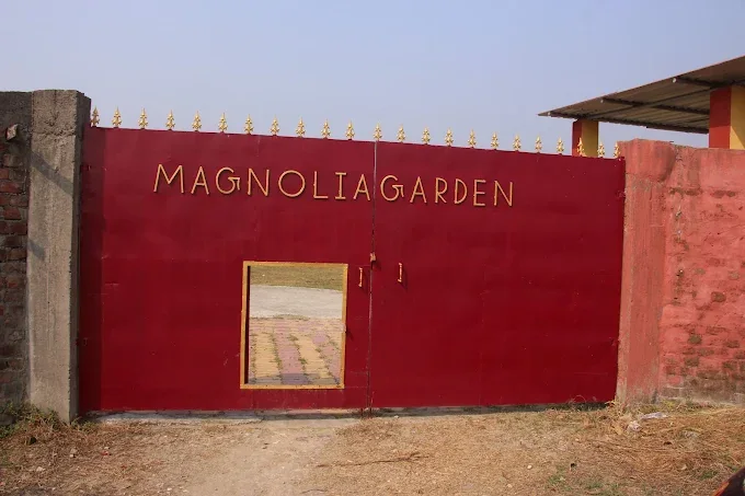 The red main gate with MAGNOLIA GARDEN in gold letters